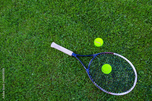 tennis racket and ball on grass