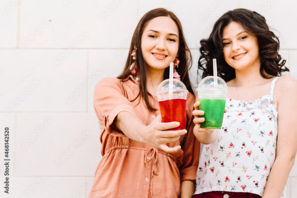 two friends women holding fresh drinks. two friends women holding fresh drinks.
