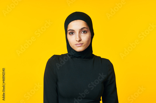 woman in muslim clothes posing islam yellow background