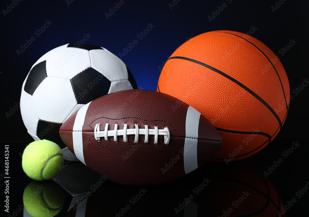 Set of different sport balls on black mirror surface