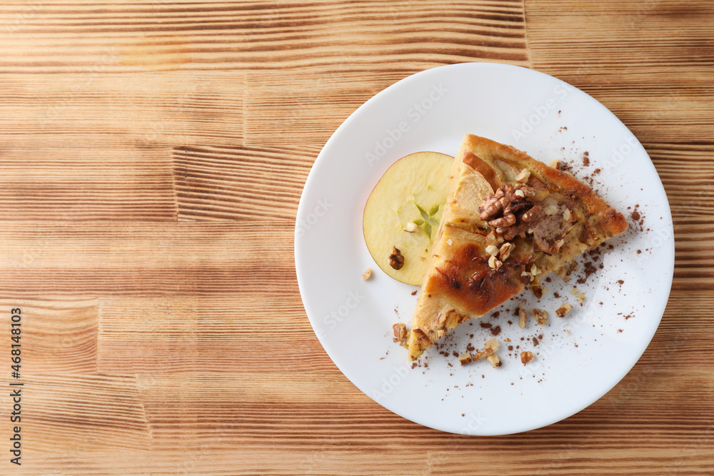 Piece of apple pie on plate on wooden background Piece of apple pie on plate on wooden background