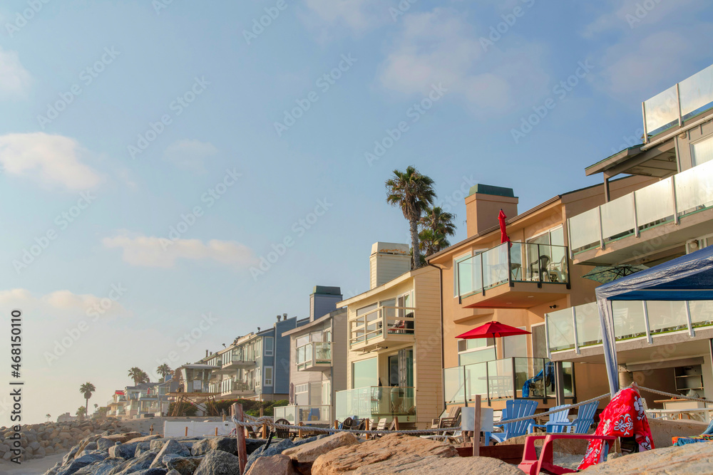 Fototapeta premium Row of beach house buildings with lounge chairs outside at Oceanside, California