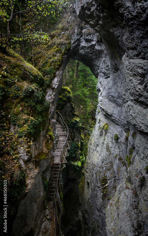 Devil's Path - picturesque eco-path and hiking trail in the Rhodopes mountains, Bulgaria. Wooden bridge under the rock formation Devils bridge Devil's Path - picturesque eco-path and hiking trail in the Rhodopes mountains, Bulgaria. Wooden bridge under the rock formation Devils bridge