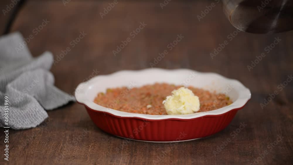 Woman making shepherd's pie. Mashed potatoes being placed on top of minced meat. Woman making shepherd's pie. Mashed potatoes being placed on top of minced meat.
