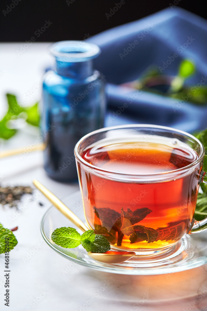 Black tea in glass transparent mug with mint leaves. Soothing tea, anti-stress Black tea in glass transparent mug with mint leaves. Soothing tea, anti-stress