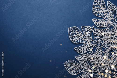 Christmas blue background. Shining silver pattern made of frost decorative leaves