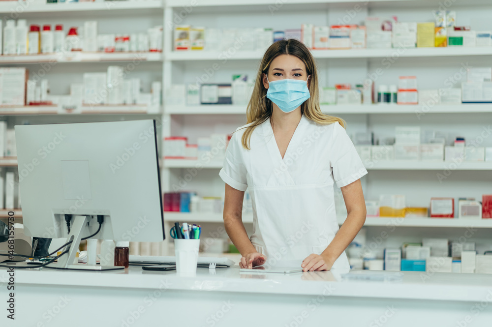 Pharmacist with protective mask on her face while working at a pharmacy