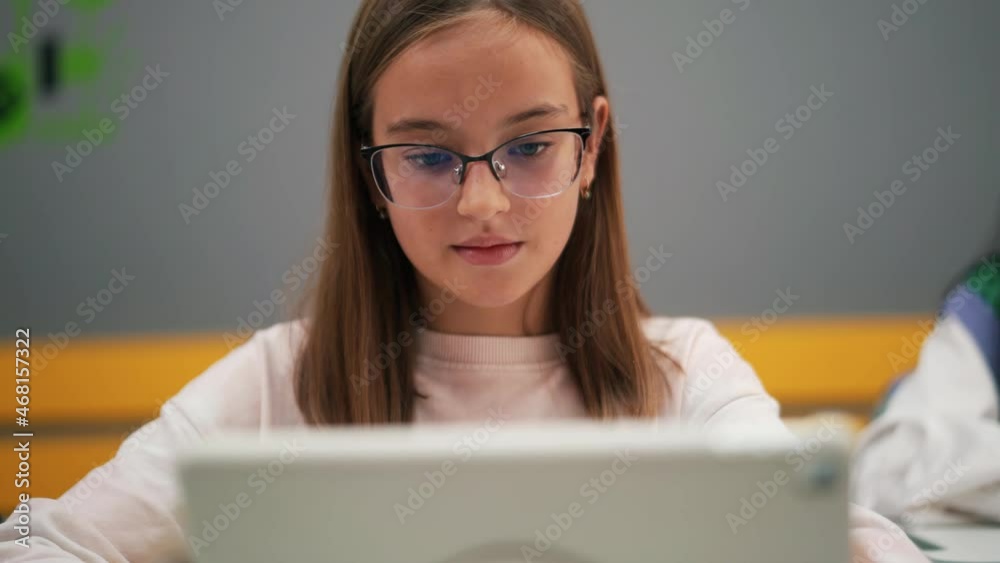 Close-up view of girl writing something in notepad at school Close-up view of girl writing something in notepad at school