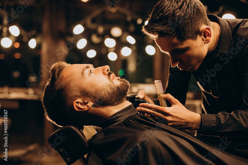 Handsome man at barbershop shaving beard