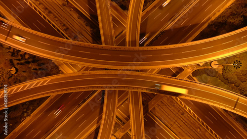 Aerial drone long exposure night photo of urban elevated road junction and interchange overpass in city with light traffic