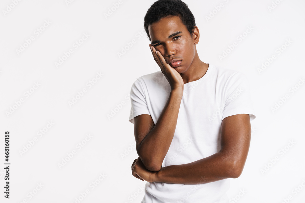 Tired black man looking at camera while propping up his head Tired black man looking at camera while propping up his head
