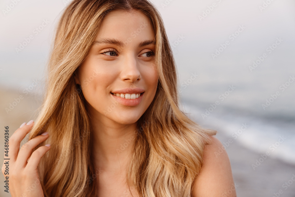 Young white woman with blonde hair smiling and looking aside Young white woman with blonde hair smiling and looking aside