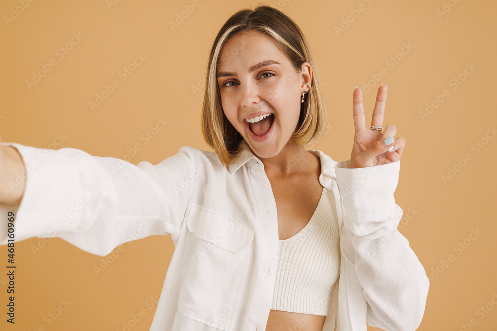 Naklejka premium Young blonde woman gesturing while taking selfie photo