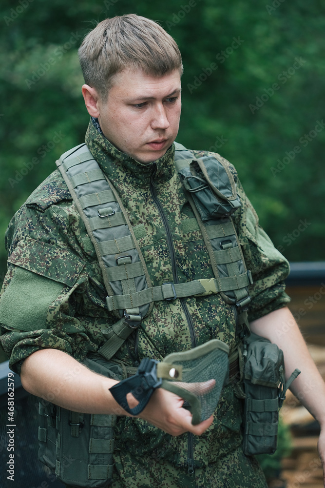 Military men with automatic weapons getting ready to play airsoft strikeball