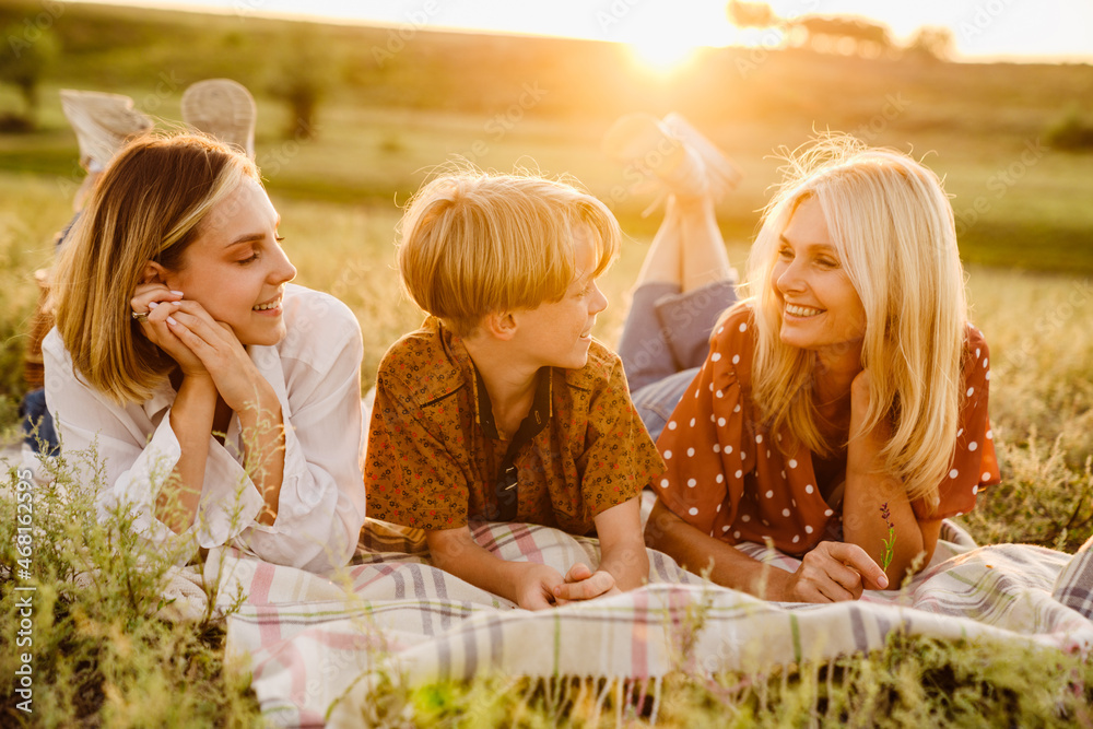 White family laughing during picnic on summer field White family laughing during picnic on summer field