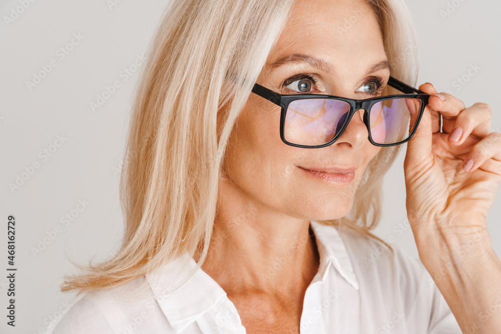 Mature woman in eyeglasses posing and looking aside Mature woman in eyeglasses posing and looking aside