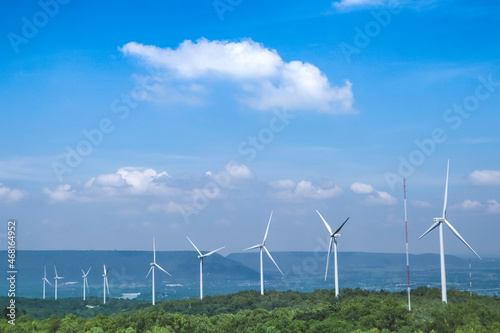 Wallpaper Mural The big white wind turbine for spinning electricity sees large mountains far away, with clouds and blue skies above the mountains. Torontodigital.ca