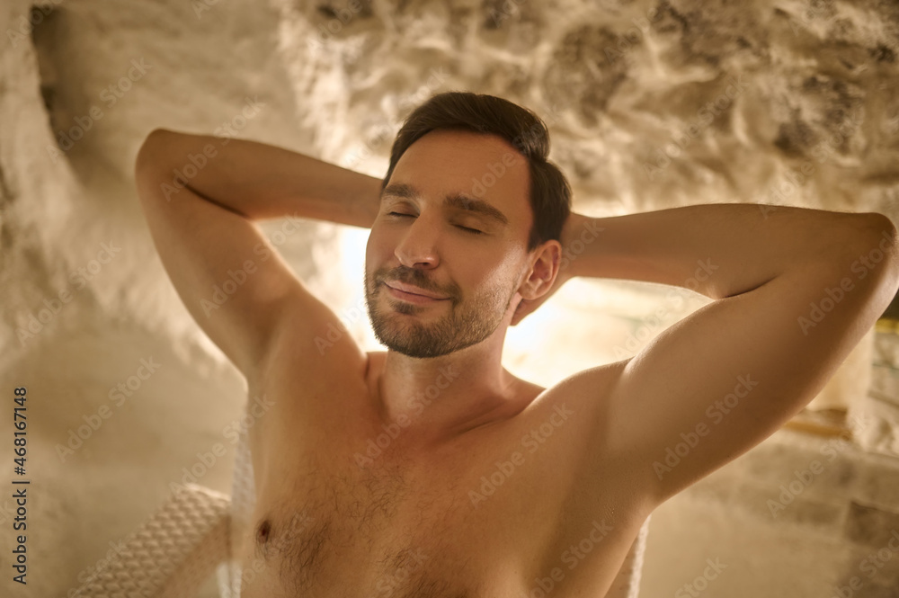 A dark-haired man looking relaxed and enjoyed while spending time in a spa center A dark-haired man looking relaxed and enjoyed while spending time in a spa center