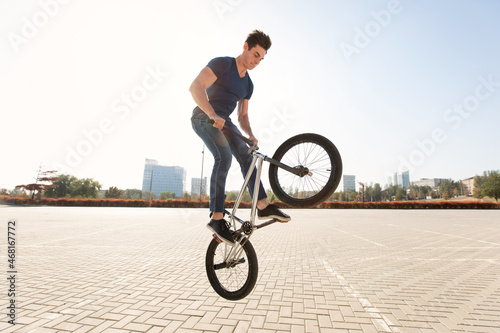 Платно Street portrait of a bmx rider in a jump on the street in the background of the