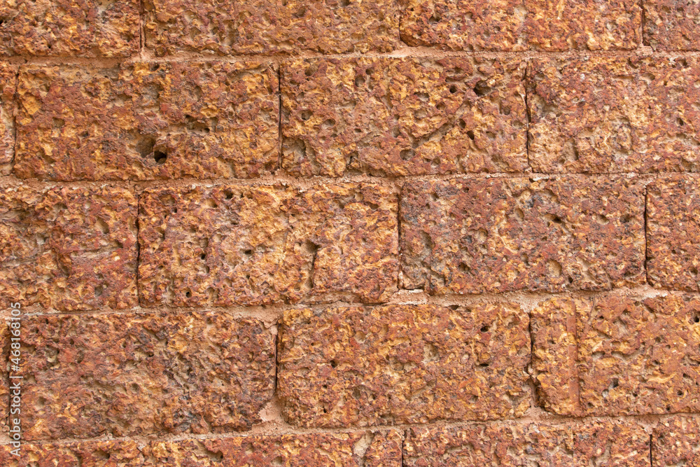 blur of red laterite brick wall Porous and fine-grained Background pattern blur of red laterite brick wall Porous and fine-grained Background pattern