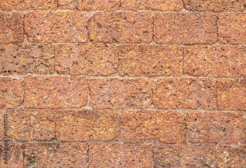 blur of red laterite brick wall Porous and fine-grained Background pattern photo