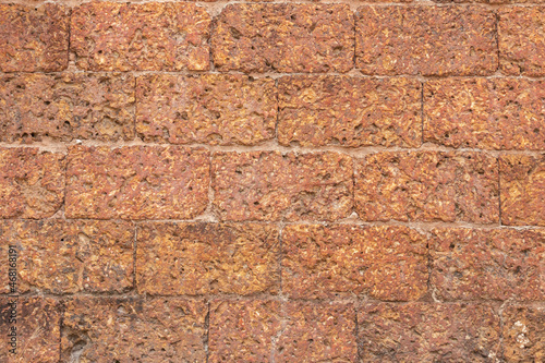 blur of red laterite brick wall Porous and fine-grained Background pattern photo