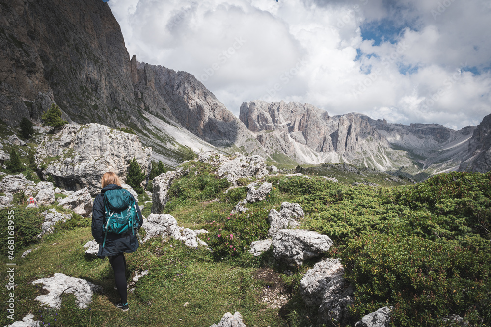 Girl hiking in dolomites. Amazing Nature Landscape near Seceda. Trentino Alto Adige, Dolomites Alps, South Tyrol, Italy. Girl hiking in dolomites. Amazing Nature Landscape near Seceda. Trentino Alto Adige, Dolomites Alps, South Tyrol, Italy.