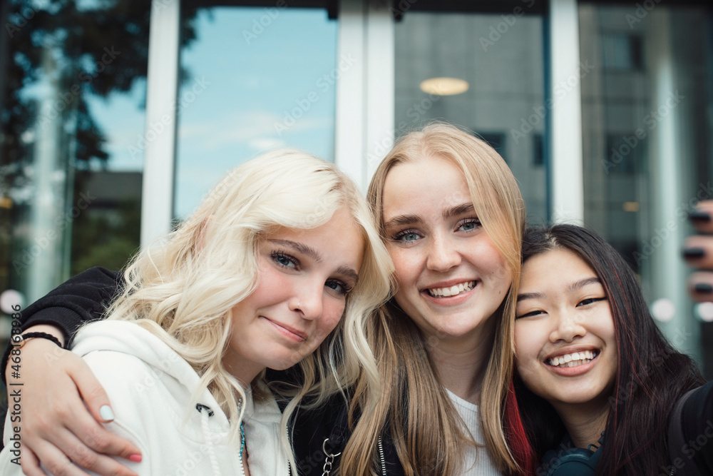 Portrait of smiling female friends outside shopping mall