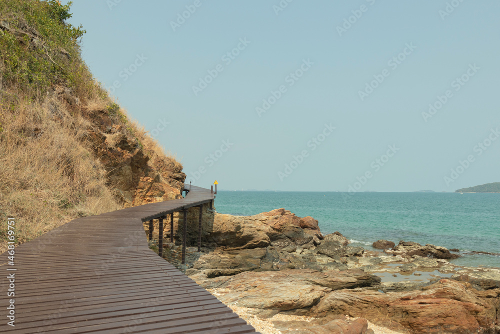 Rocks on the beach are rocks and brown wooden bridges along the hillsides, rocky mountains and sea close to island, eco-tourism concept