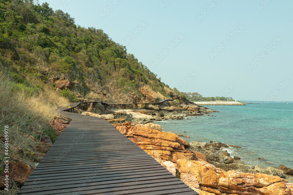 brown wooden bridges along the hillsides rocks on the beach are rocks and  rocky mountains and sea close to island, eco-tourism concept