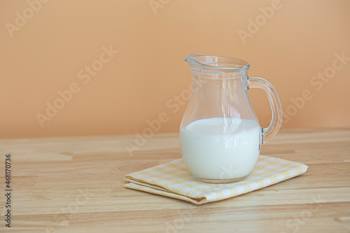 small jug of milk on wooden table.