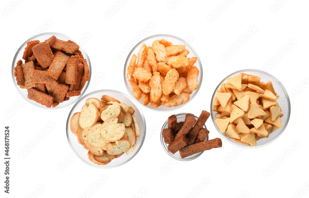 Different crispy rusks in bowls on white background, top view