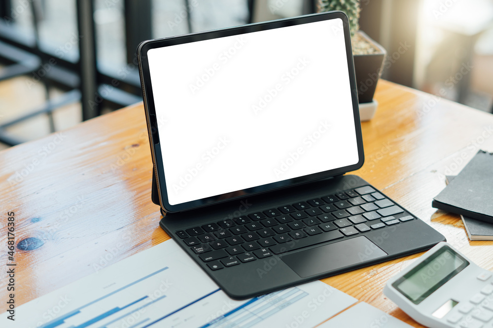 Cropped shot of simple workspace with blank screen laptop on wooden table with blurred office room background,clipping path. Cropped shot of simple workspace with blank screen laptop on wooden table with blurred office room background,clipping path.