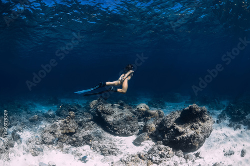 Woman freediver underwater in ocean. Freediving with fins in deep sea