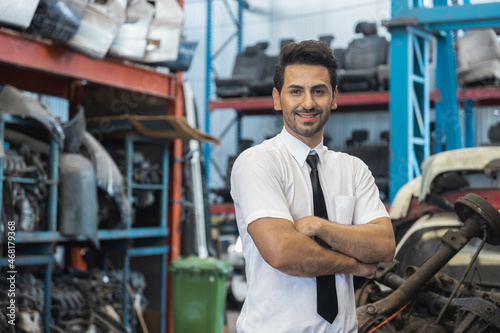 Portrait of confident business man in old parts of car factory