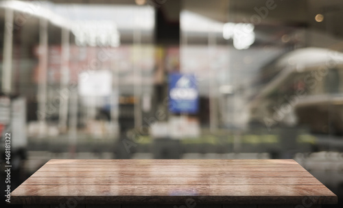 Empty wooden table top with lights bokeh on blur restaurant background.