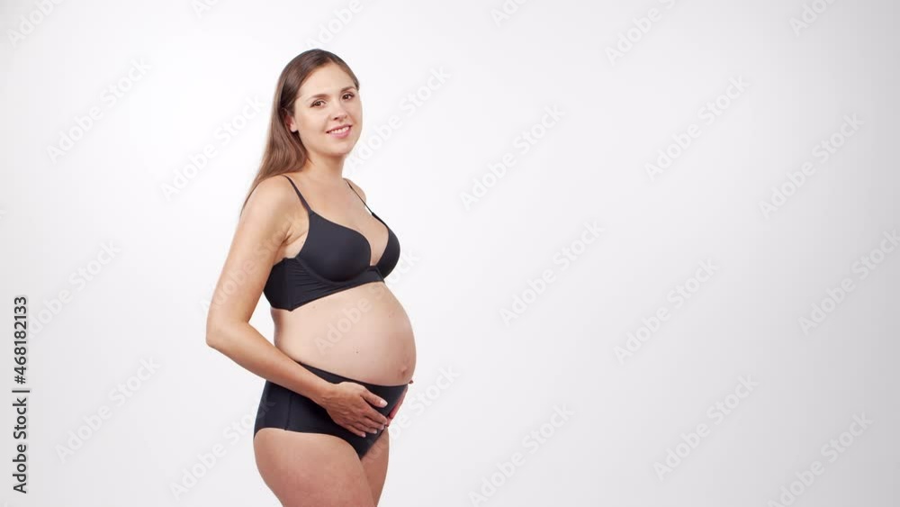 Young, happy and healthy pregnant woman on white background. Studio video. Baby expectation, pregnancy and motherhood concept. Young, happy and healthy pregnant woman on white background. Studio video. Baby expectation, pregnancy and motherhood concept.