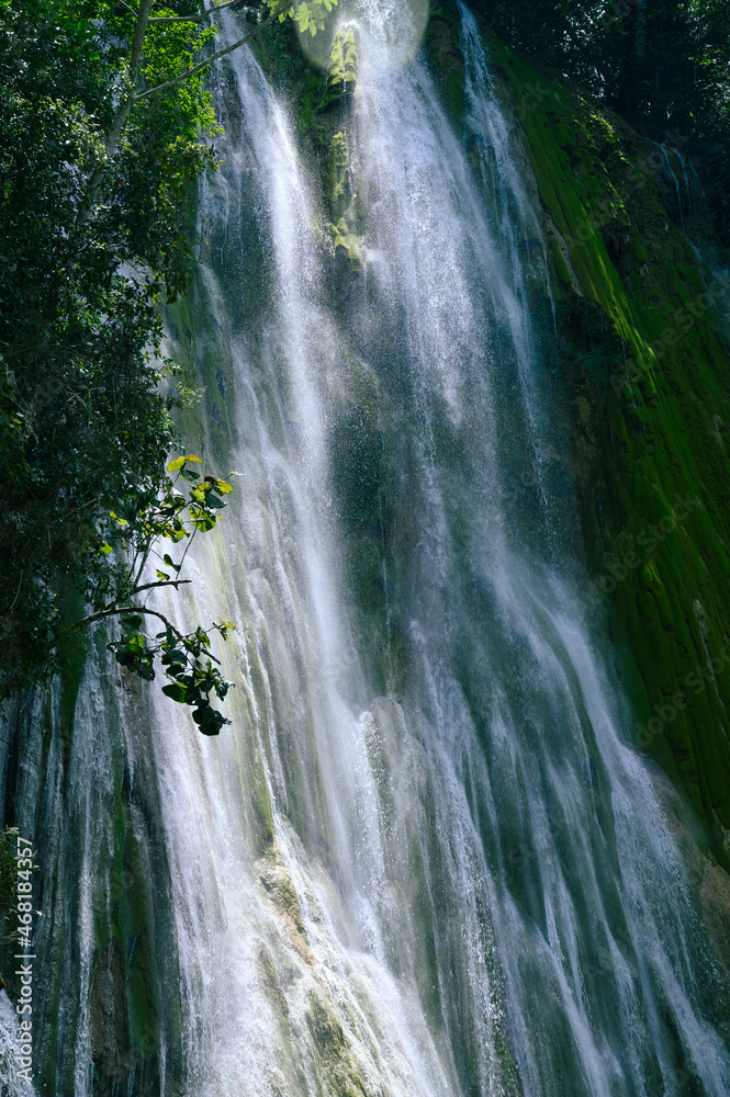 Fototapeta premium mountain nature water fall in paradise island river slide. The photo of the waterfall was taken in the Dominican Republic in the rainforest. The picture of the jungle with water impresses with its pri