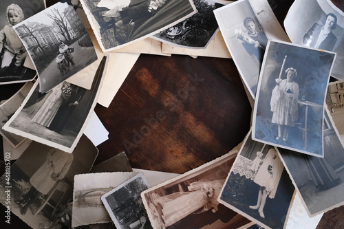 on an old wooden table there are old photographs of 1950-1960, , concept of family tree, genealogy, childhood memories, connection with ancestors photo