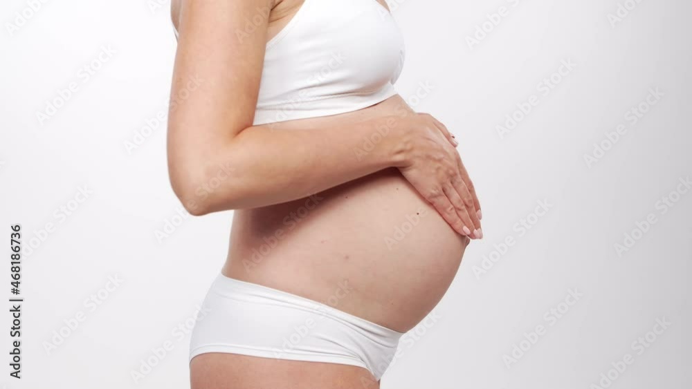 Young, happy and healthy pregnant woman on white background. Studio video. Baby expectation, pregnancy and motherhood concept. Young, happy and healthy pregnant woman on white background. Studio video. Baby expectation, pregnancy and motherhood concept.