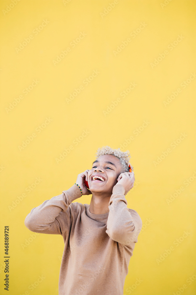Portrait of Smiling Young man using red headphones and dancing Against yellow Background Portrait of Smiling Young man using red headphones and dancing Against yellow Background