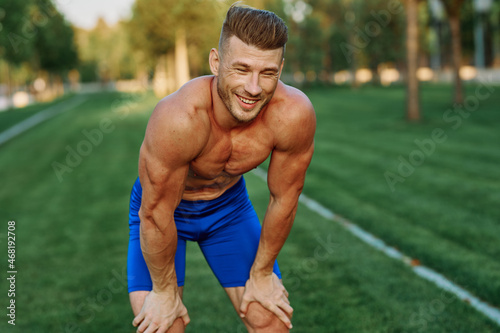 sporty man with pumped up body in park workout exercise © VICHIZH