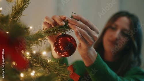 Ragazza appende pallina per Natale photo