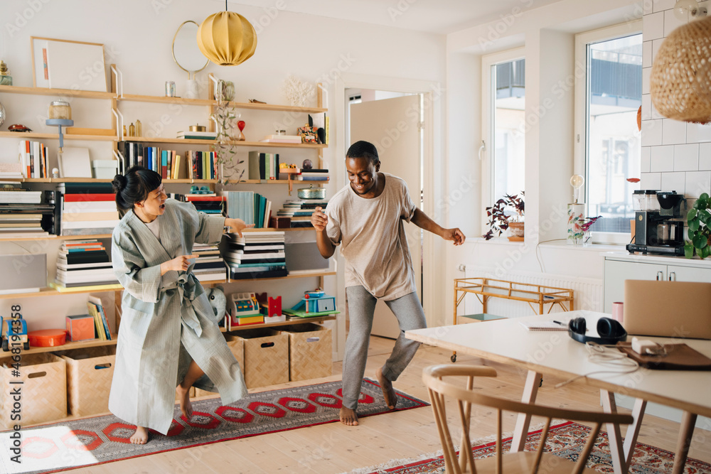 Cheerful couple dancing in living room at home Cheerful couple dancing in living room at home