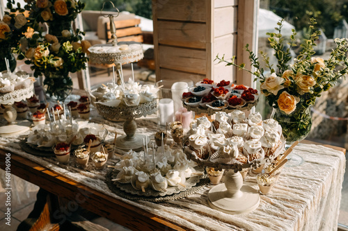 Candy bar table setting with flower decorations at a wedding. © Bostan Natalia