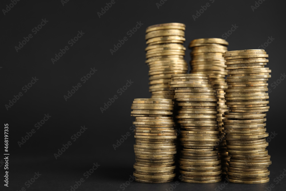 Many Euro coins stacked on black background, space for text Many Euro coins stacked on black background, space for text