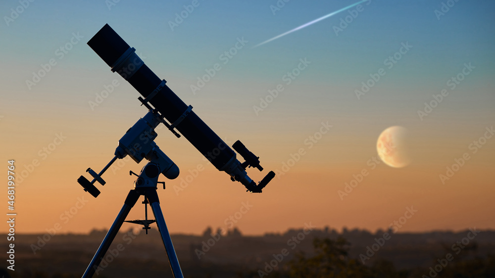 Silhouette of astronomical telescope and countryside.