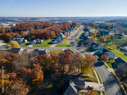 Aerial view of Eau Claire, Wisconsin, residential neighborhood in autumn. Wide streets with curbs and sidewalks. Large homes and yards. Park nearby.