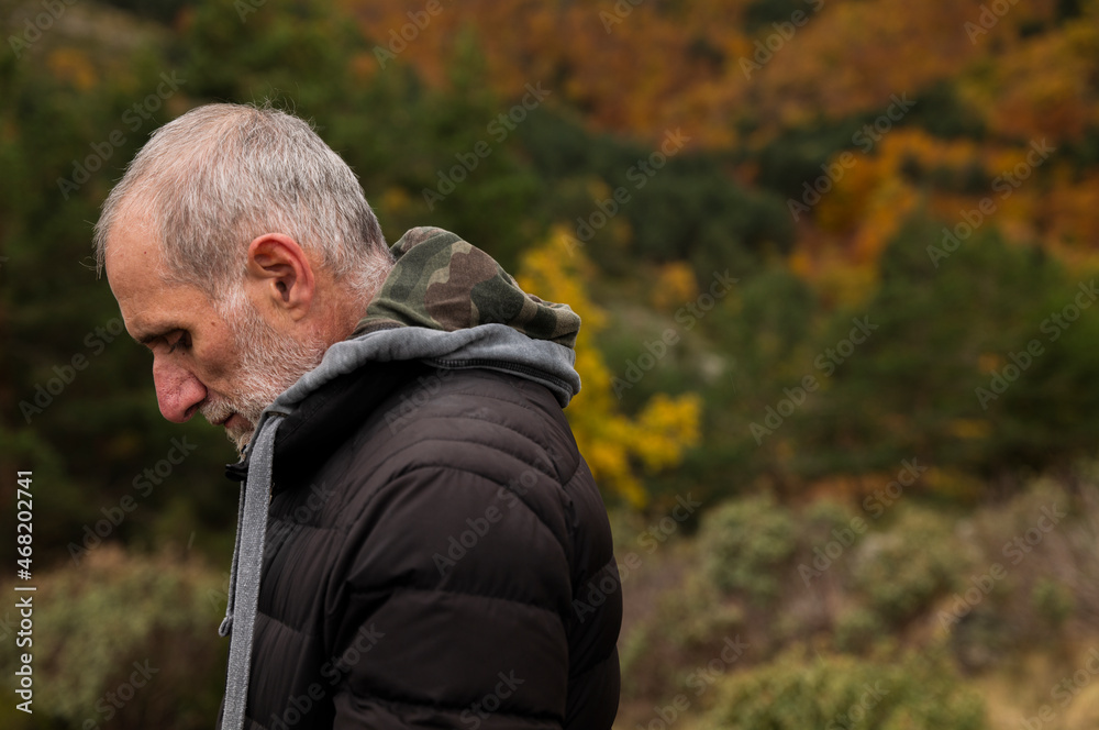 Portrait of adult man in black winter jacket against autumn color trees on mountain, in Tejera Negra, Cantalojas, Guadalajara, Spain Portrait of adult man in black winter jacket against autumn color trees on mountain, in Tejera Negra, Cantalojas, Guadalajara, Spain