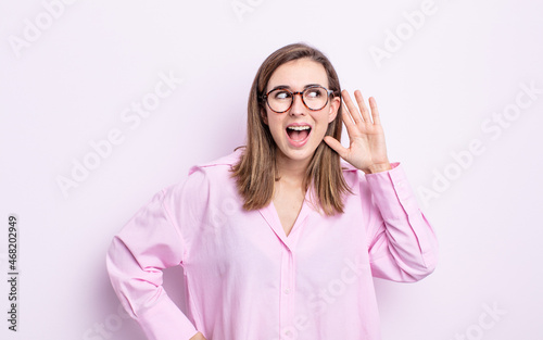 young pretty girl smiling, looking curiously to the side, trying to listen to gossip or overhearing a secret photo